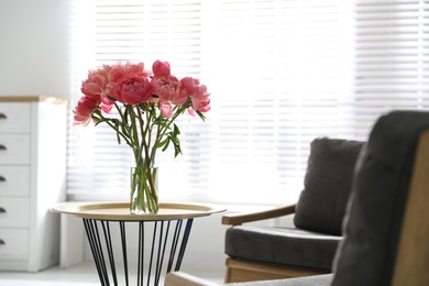 Beautiful bouquet of fragrant peonies in vase on table indoors. Space for text