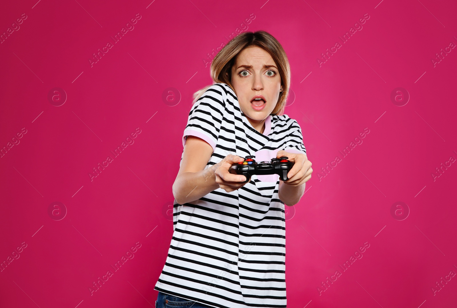 Photo of Emotional young woman playing video games with controller on color background