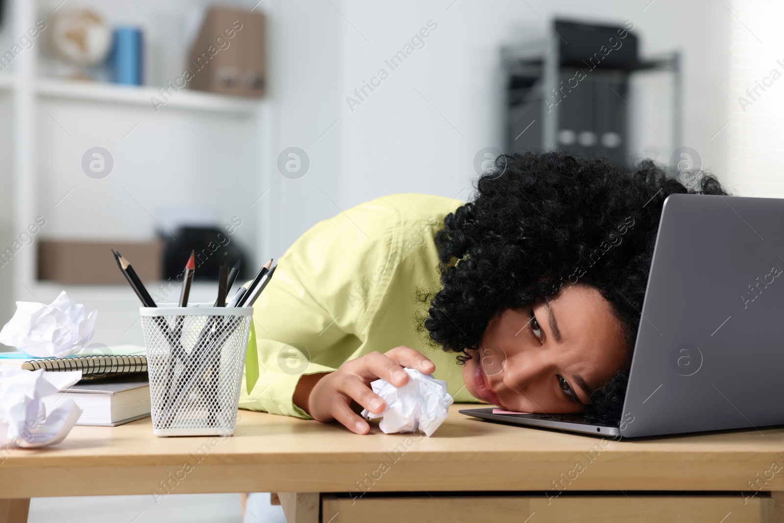 Photo of Stressful deadline. Tired woman with crumpled paper in office