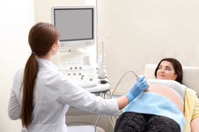 Young pregnant woman undergoing ultrasound scan in clinic