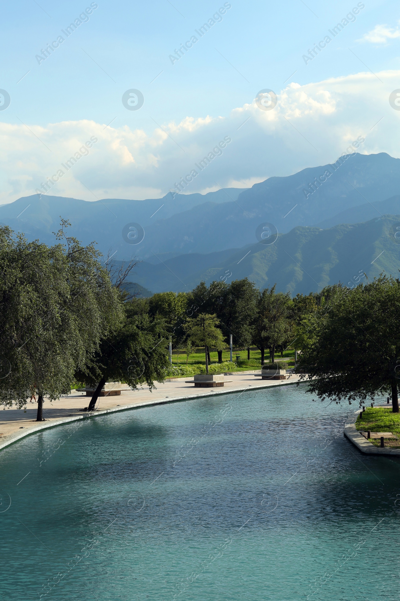 Photo of Picturesque view of canal, green trees in park