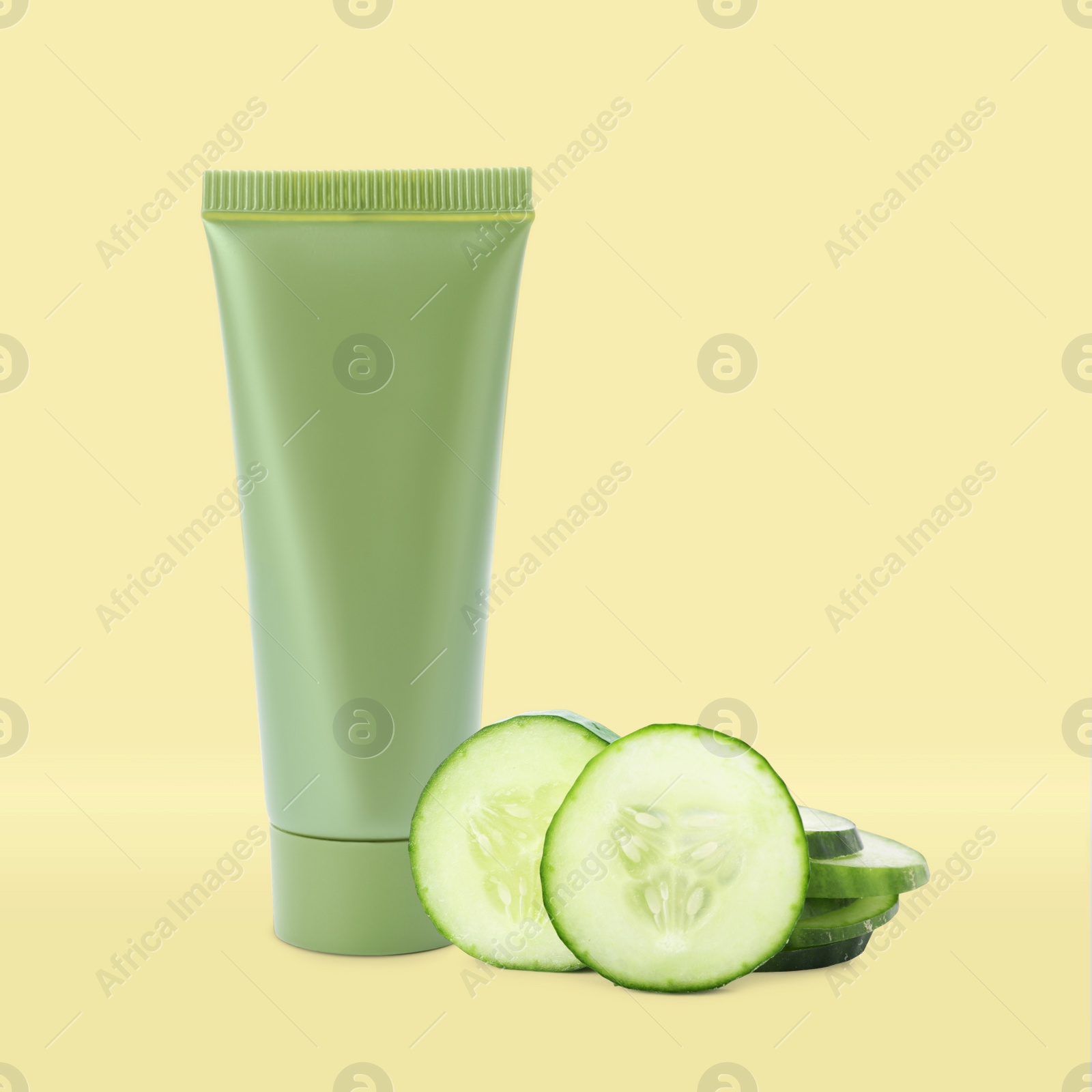 Image of Makeup remover and fresh cucumber on yellow background