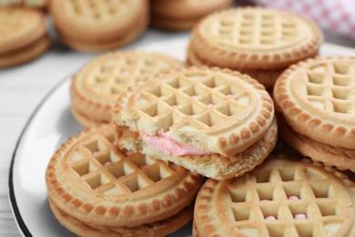 Photo of Tasty sandwich cookies with cream on plate, closeup