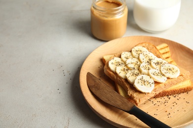Photo of Tasty toasts with banana, peanut butter and chia seeds served on table. Space for text