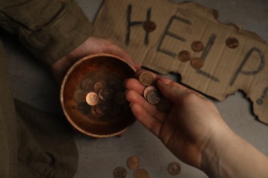 Woman giving coins to homeless, closeup. Charity and donation