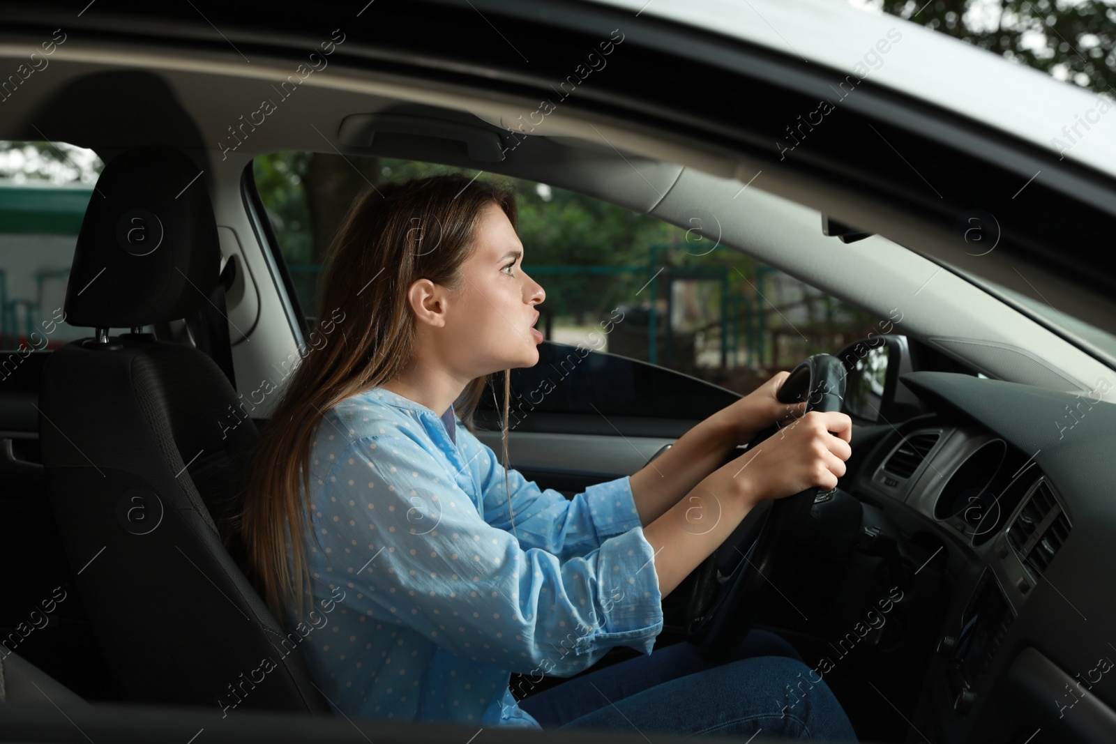 Photo of Stressed young woman in driver's seat of modern car