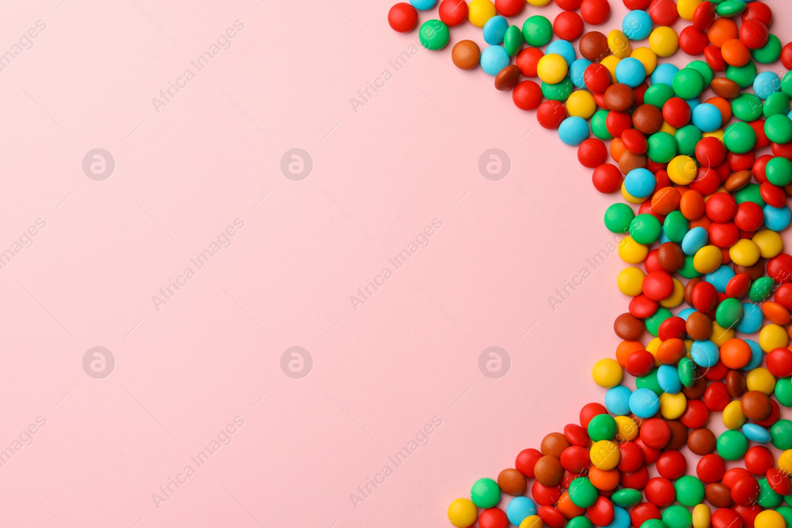 Photo of Tasty colorful candies on pink background, flat lay. Space for text