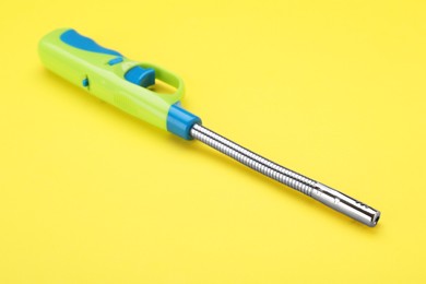 Photo of One bright gas lighter on yellow background