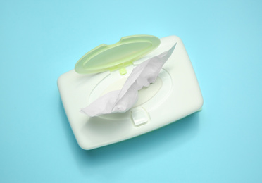 Holder with paper tissues on light blue background, top view