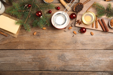 Photo of Flat lay composition with ingredients for traditional Christmas cake on wooden table. Space for text