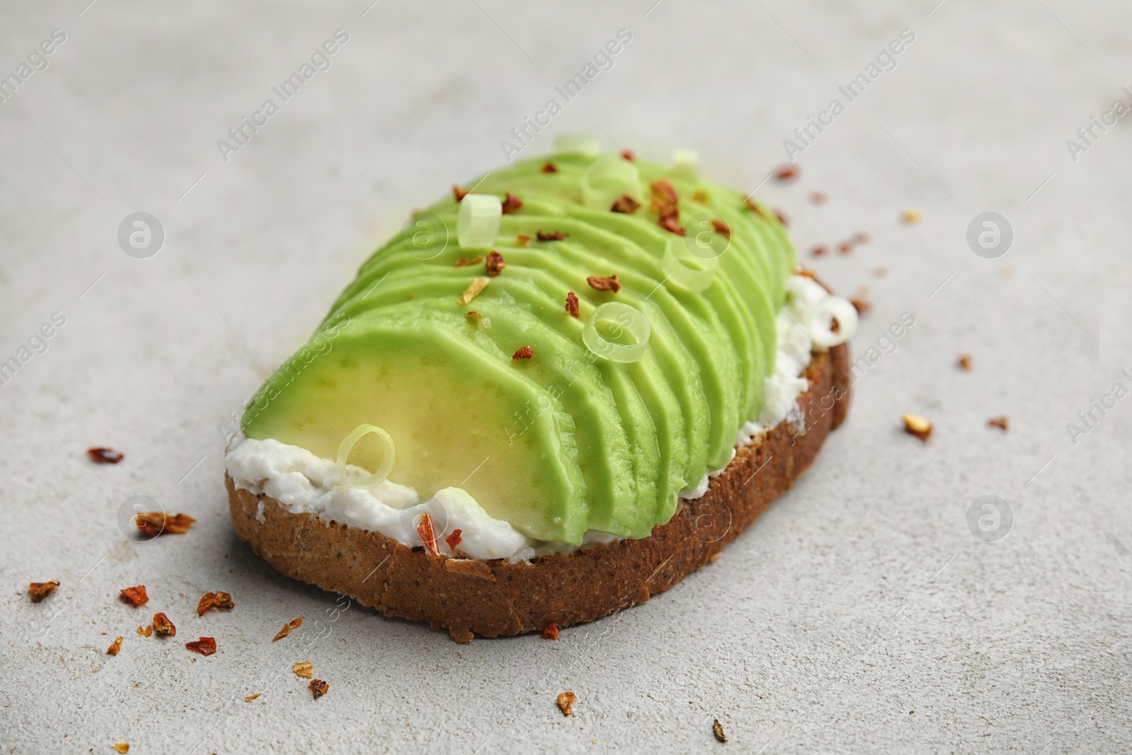 Photo of Crisp rye toast with sliced avocado and cream cheese on table