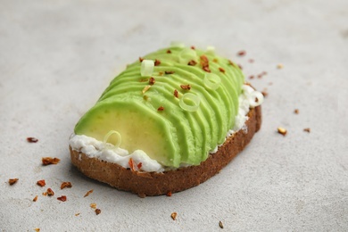 Crisp rye toast with sliced avocado and cream cheese on table