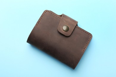 Photo of Stylish leather card holder on light blue background, top view