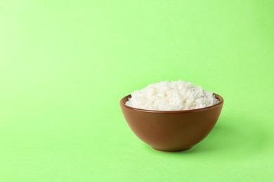 Photo of Bowl of boiled rice on color background. Space for text