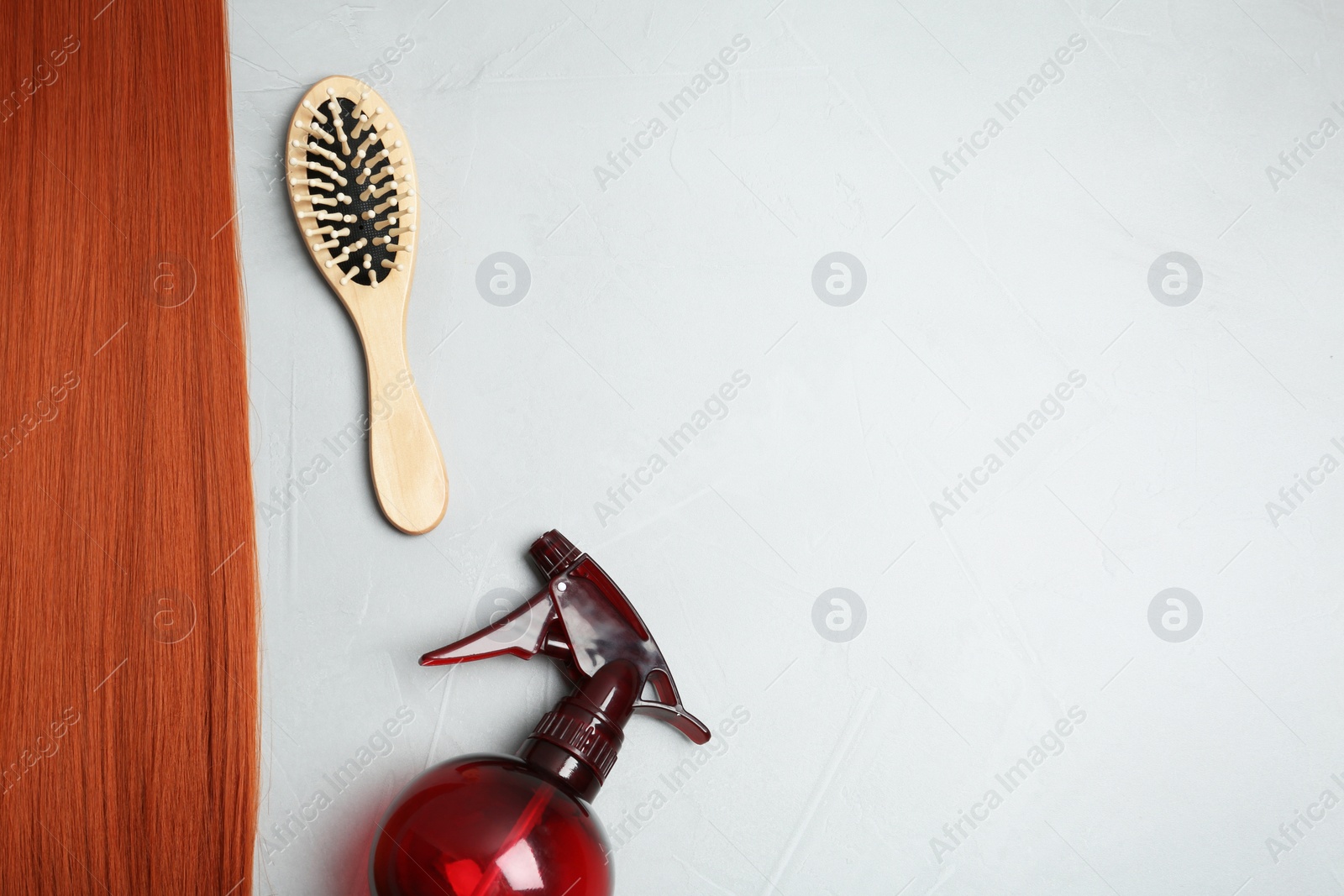Photo of Flat lay composition with red hair and hairdresser's tools on light background. Space for text