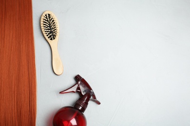 Flat lay composition with red hair and hairdresser's tools on light background. Space for text