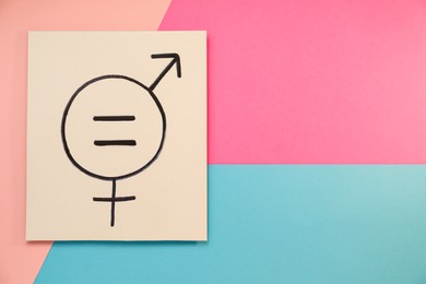 Photo of Card with equal sign and gender symbols on color background, top view. Space for text