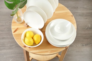 Different clean tableware on wooden table in kitchen