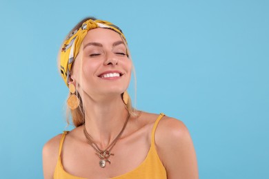 Photo of Portrait of happy hippie woman on light blue background. Space for text