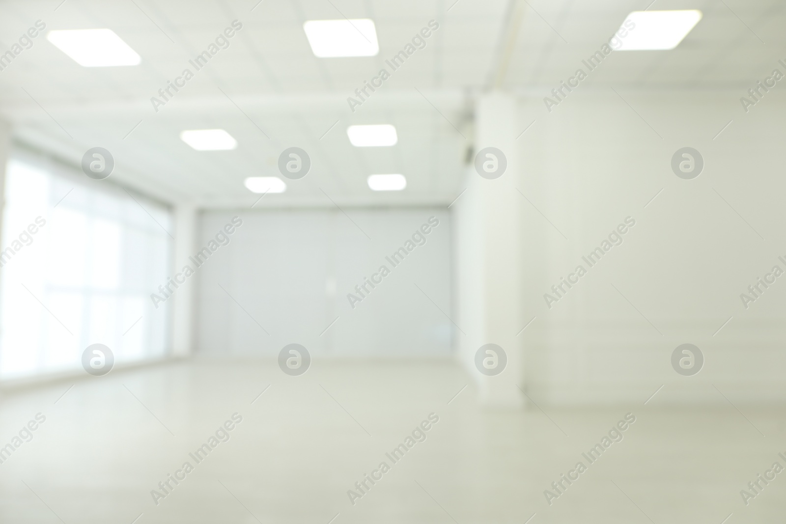 Photo of Empty room with white walls and laminated flooring, blurred view