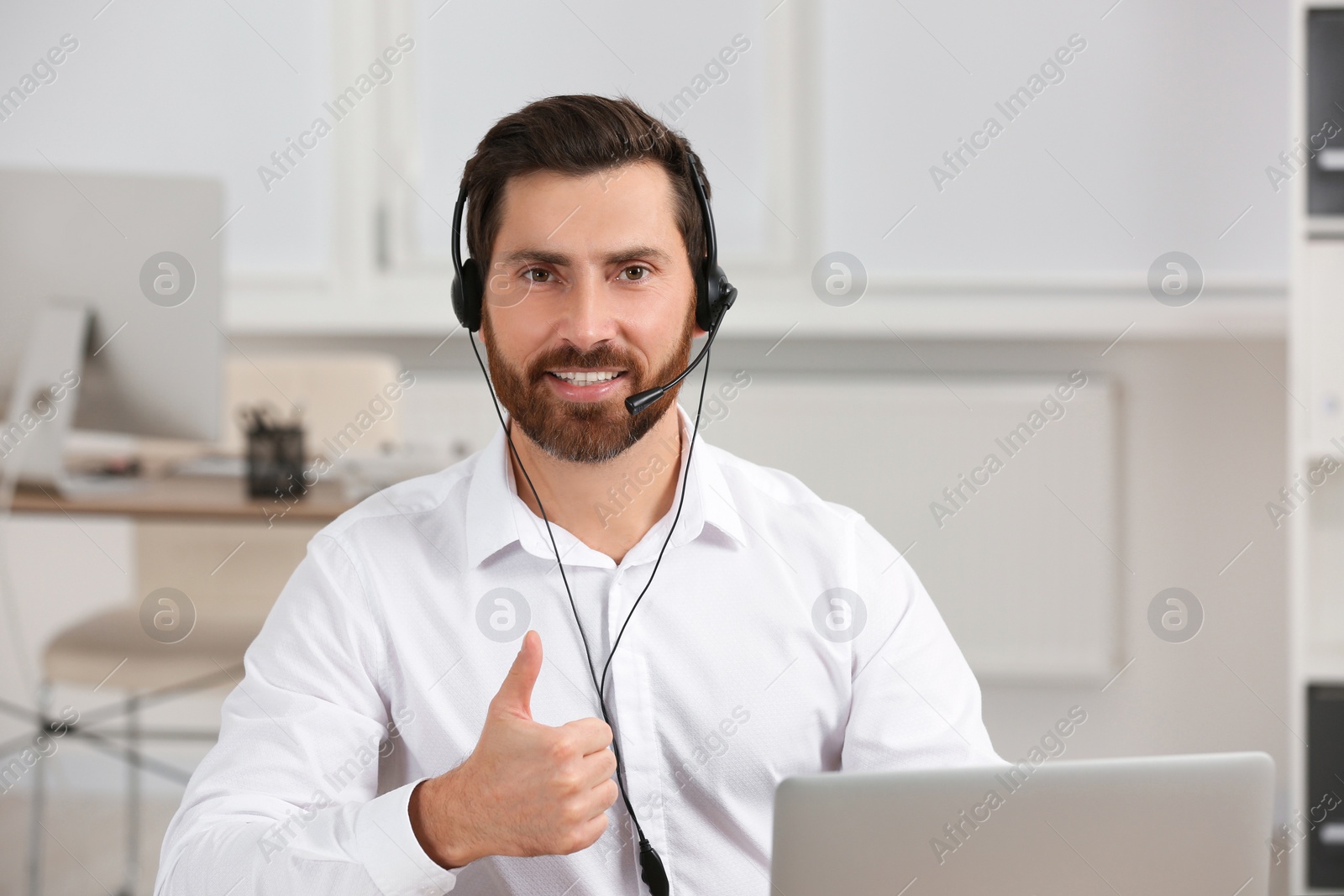 Photo of Hotline operator with headset working in office