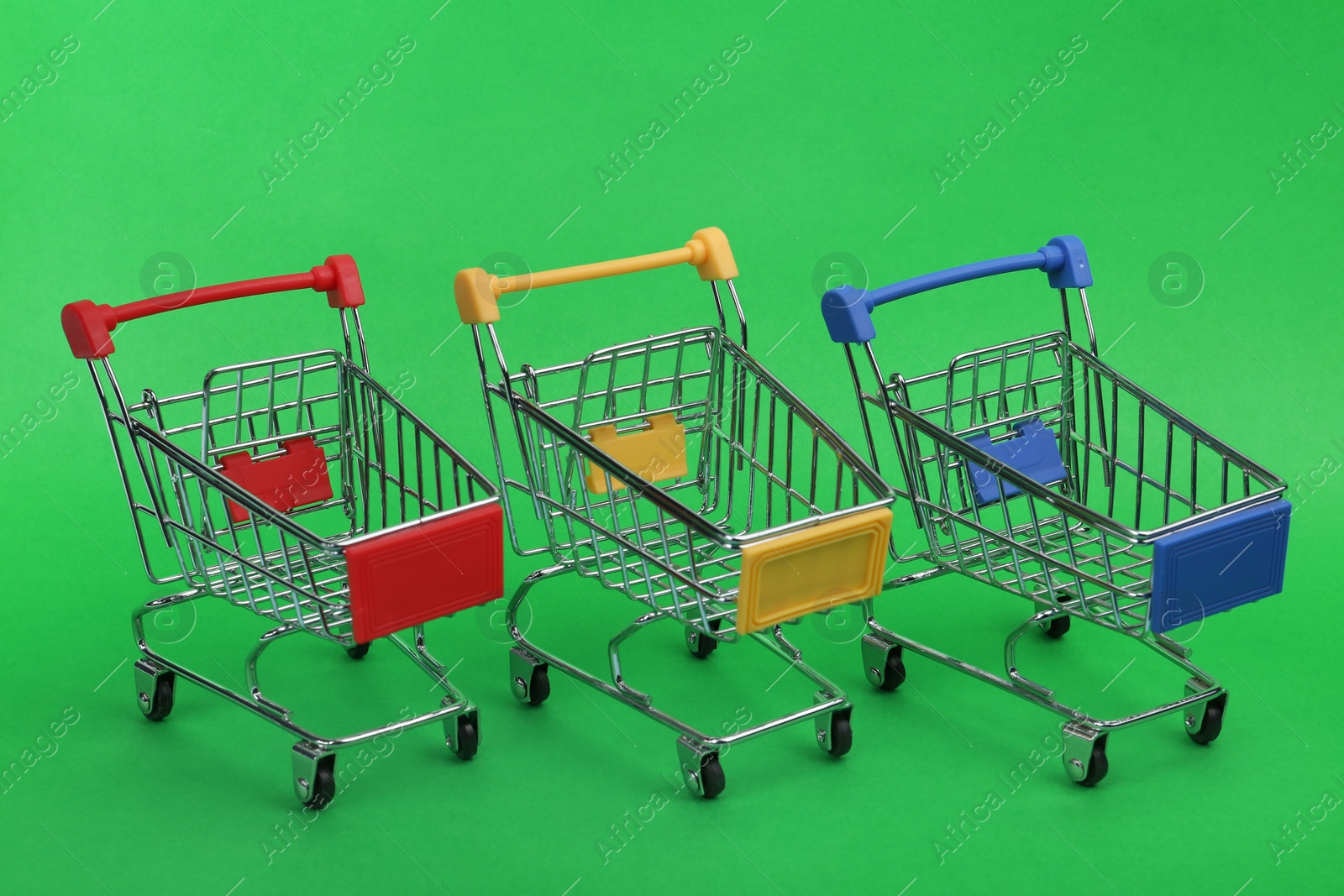 Photo of Row of empty shopping trolleys on color background