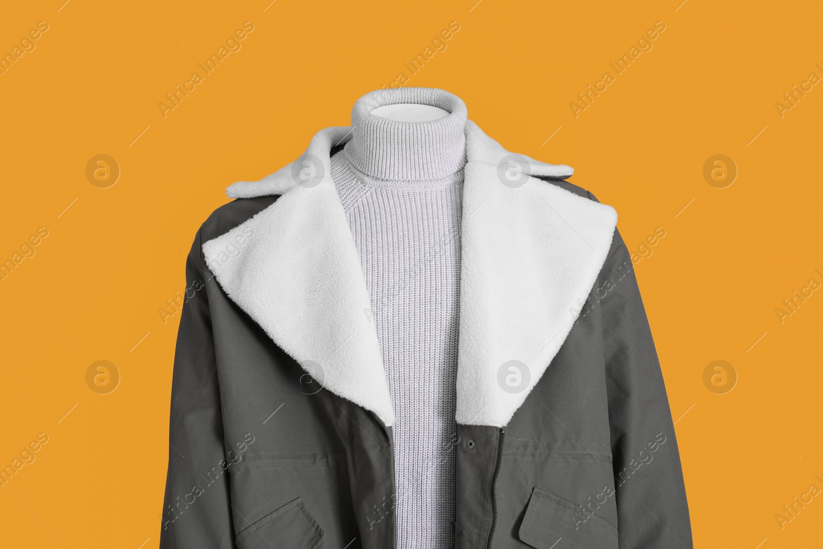 Photo of Female mannequin dressed in stylish jacket and turtleneck on orange background