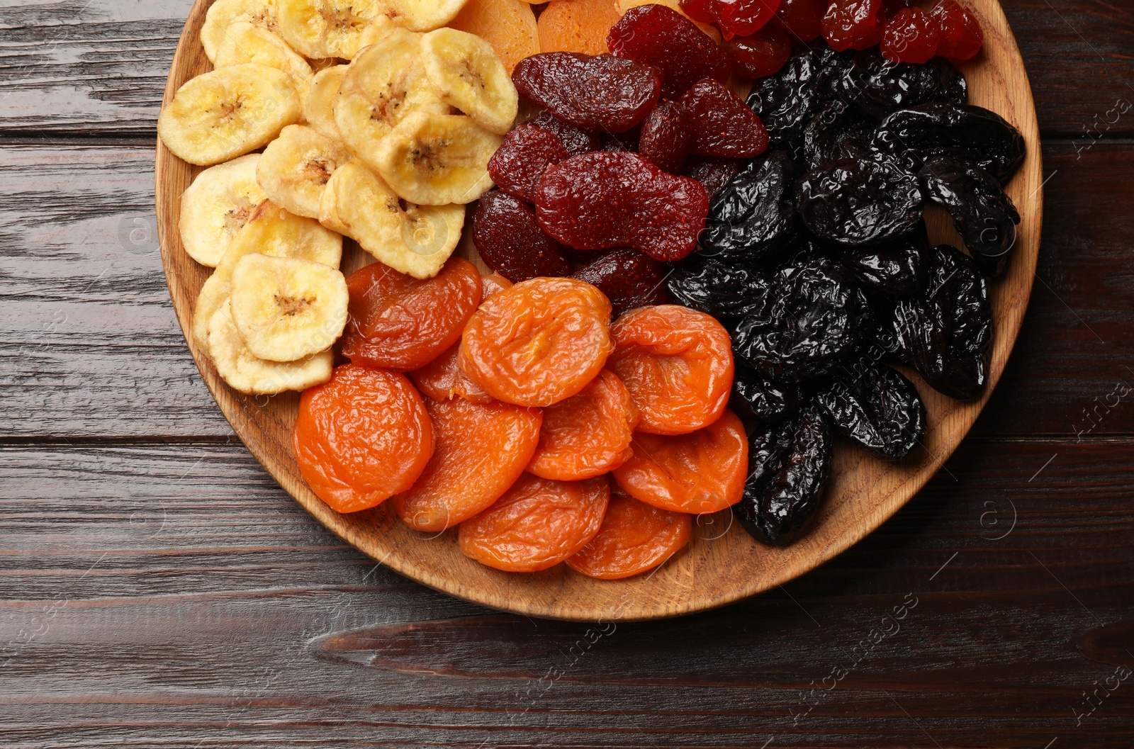 Photo of Delicious dried fruits on wooden table, top view