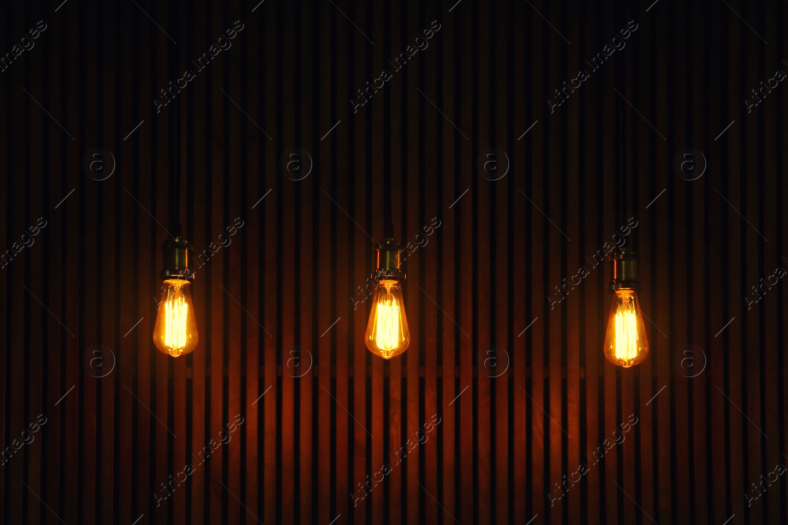 Photo of Pendant lamps with light bulbs on wooden background