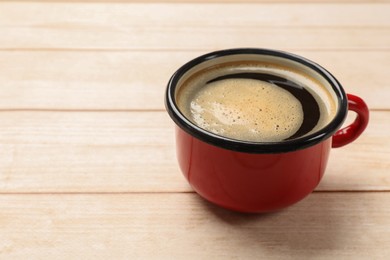 Photo of Cup of aromatic coffee on light wooden table, closeup. Space for text
