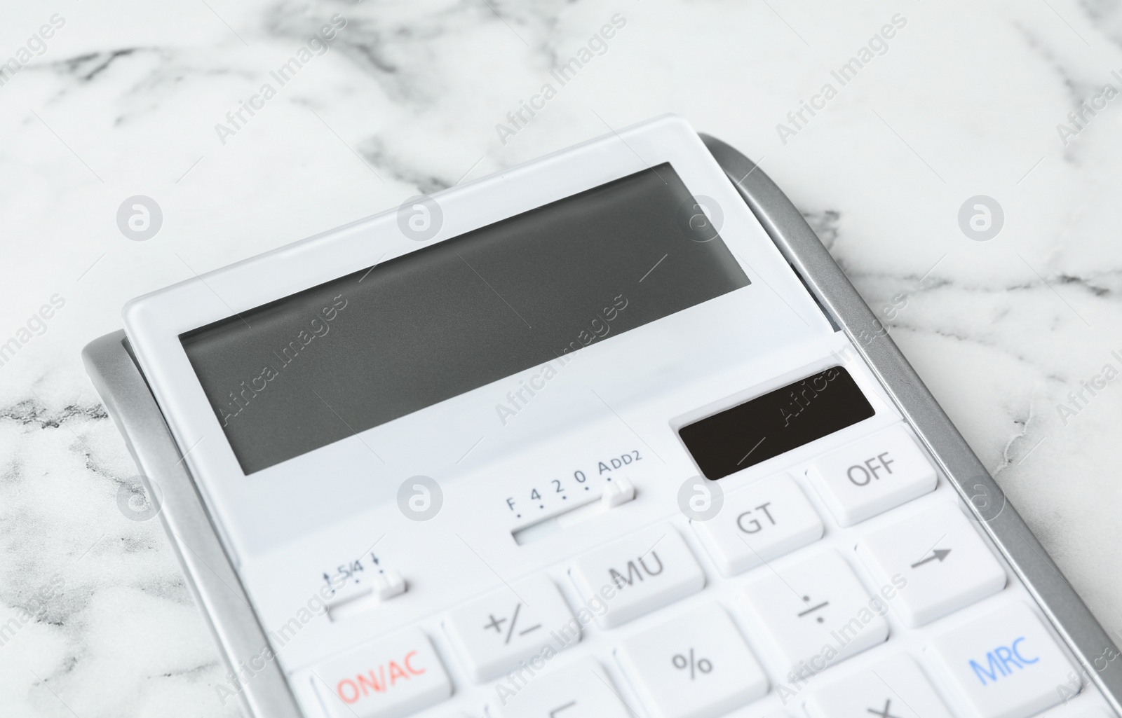 Photo of Calculator on white marble background, closeup. Tax accounting concept