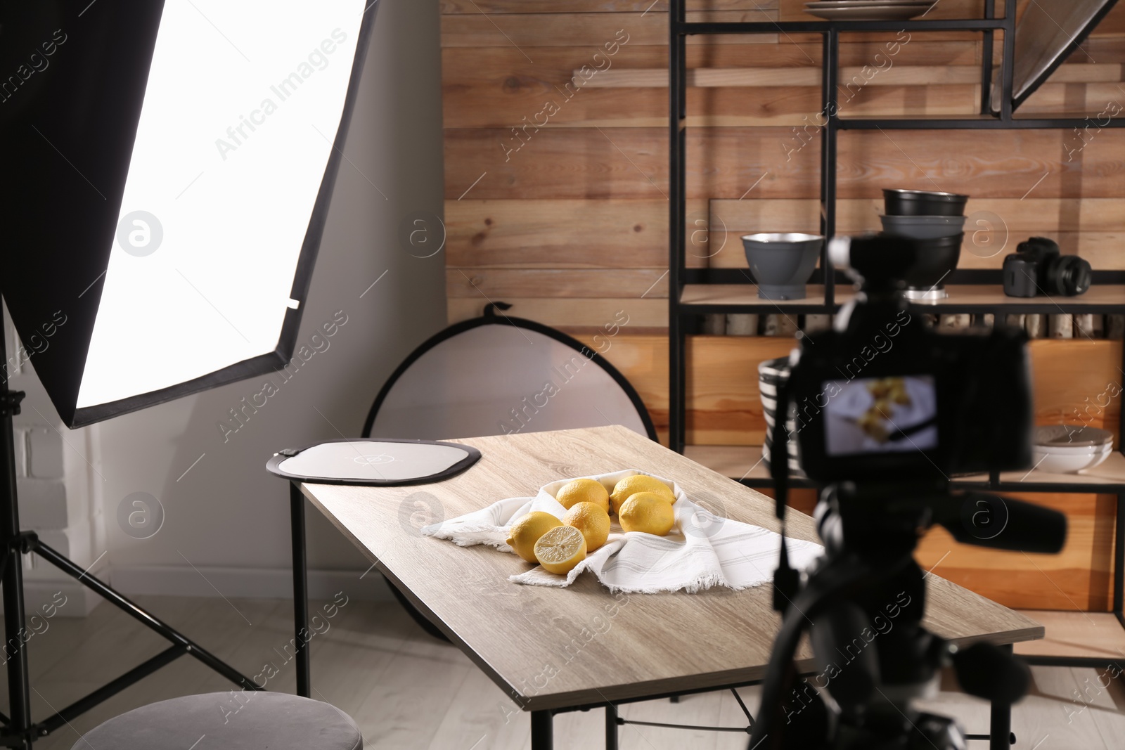 Photo of Professional equipment and many lemons on table in studio. Food photo
