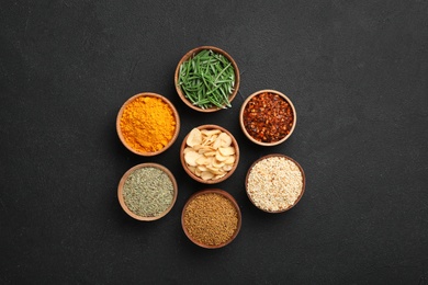 Flat lay composition with different aromatic spices on dark background