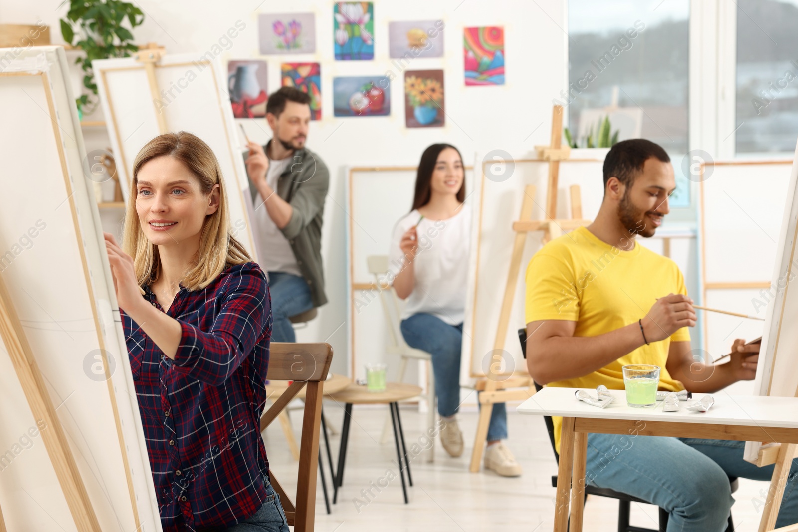 Photo of Group of students attending painting class in studio. Creative hobby