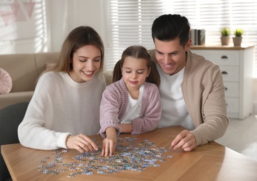 Photo of Happy family playing with puzzles at home