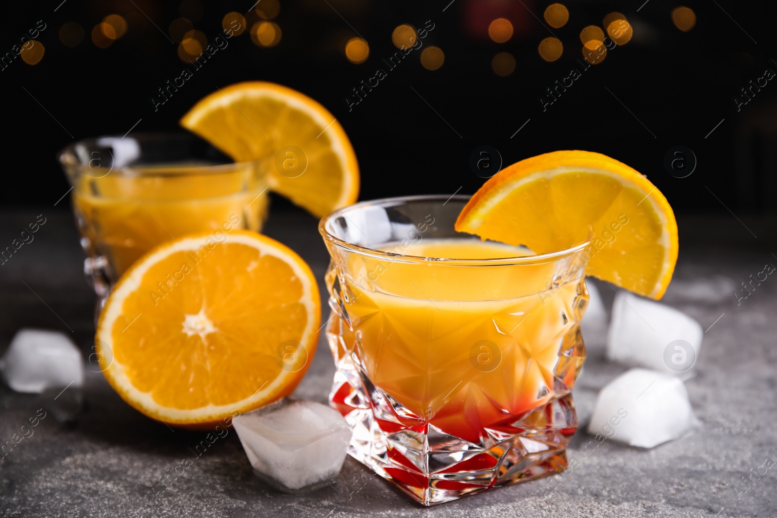 Photo of Fresh alcoholic Tequila Sunrise cocktail on grey table