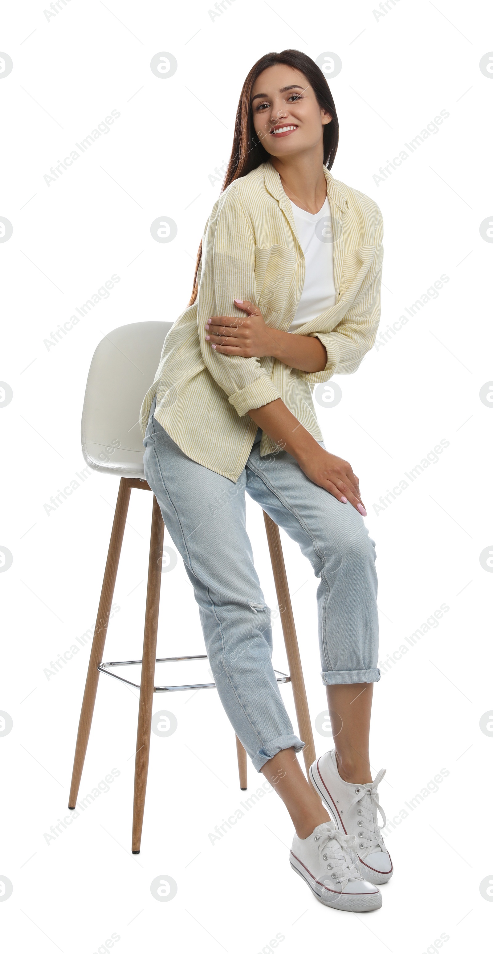 Photo of Beautiful young woman sitting on stool against white background