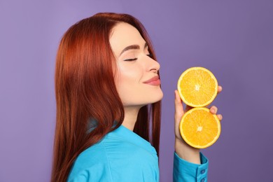 Photo of Beautiful woman with red dyed hair and oranges on purple background