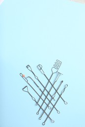 Photo of Set of logopedic probes for speech therapy on light blue background, flat lay. Space for text