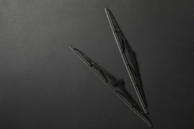 Photo of Car windshield wipers on black background, flat lay. Space for text
