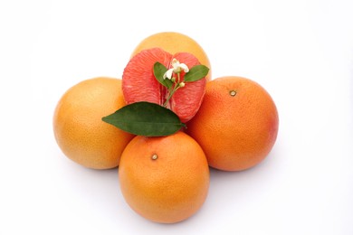 Fresh grapefruits and green leaves on white background