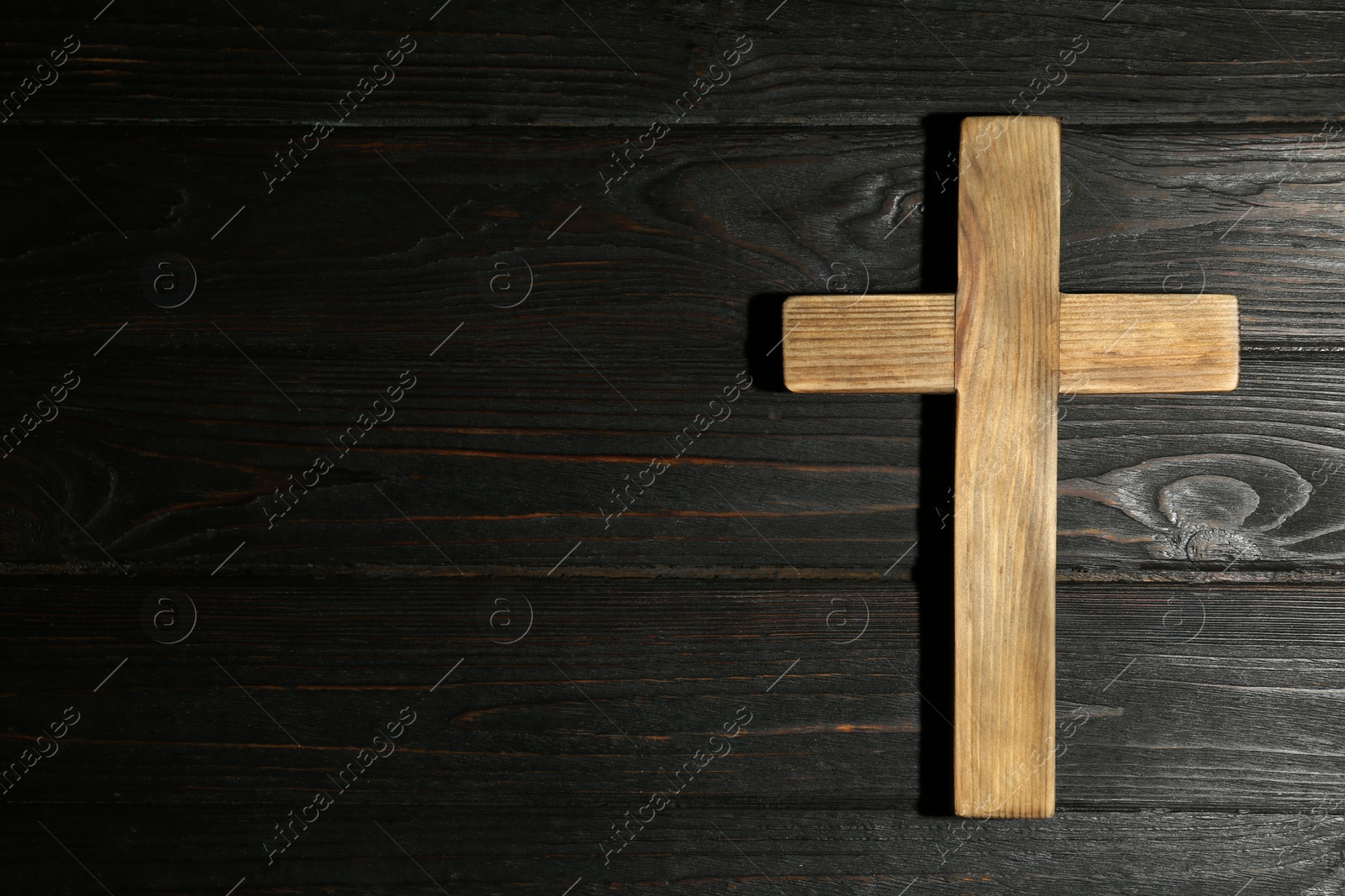 Photo of Christian cross on wooden background, top view with space for text. Religion concept