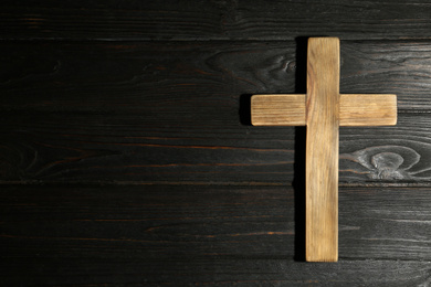 Photo of Christian cross on wooden background, top view with space for text. Religion concept