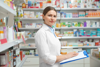 Image of Professional pharmacist with clipboard in modern drugstore
