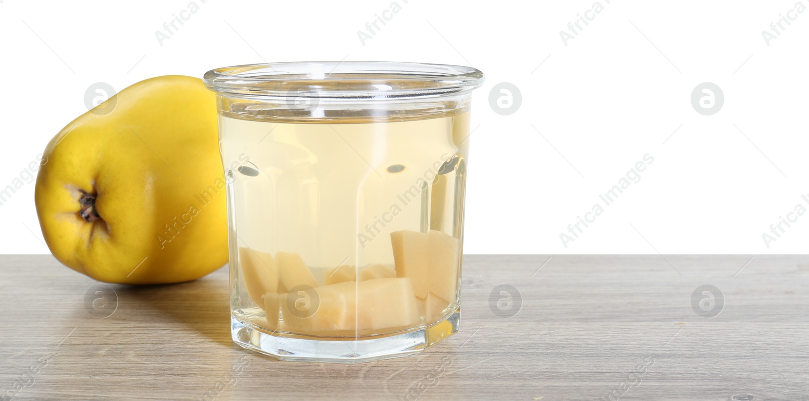 Photo of Delicious quince drink and fresh fruit on wooden table against white background