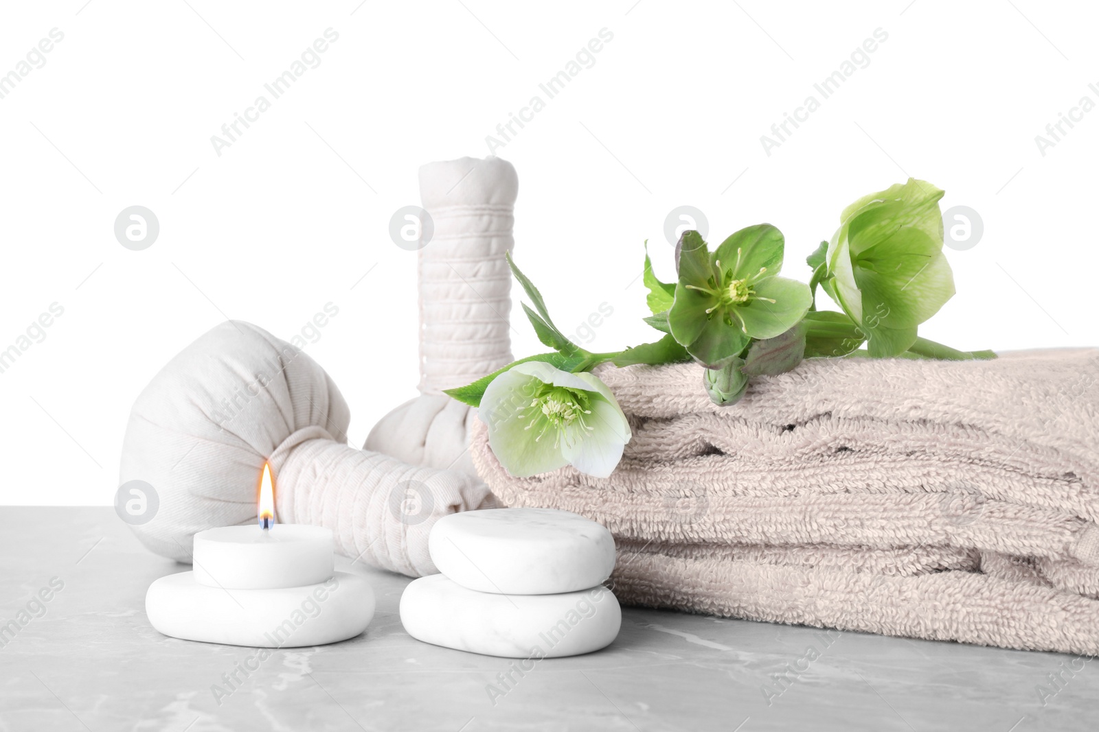 Photo of Composition with flowers and spa supplies on marble table against white background