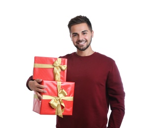 Happy young man holding Christmas gifts on white background