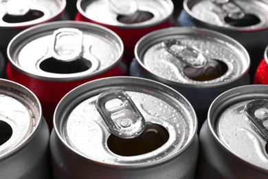 Photo of Energy drinks in wet cans as background, closeup. Functional beverage