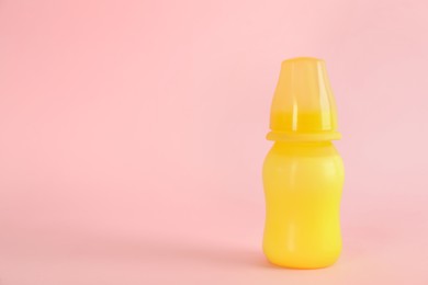 Photo of Feeding bottle with infant formula on pink background, space for text. Baby milk