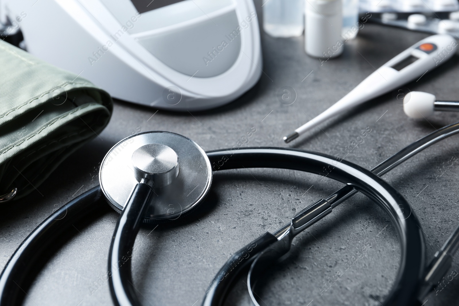 Photo of Stethoscope and other medical objects on grey table